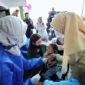 Seorang anak tengah menerima imunisasi polio