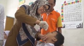 Seorang anak tengah mendapatkan imunisasi polio.