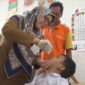 Seorang anak tengah mendapatkan imunisasi polio.